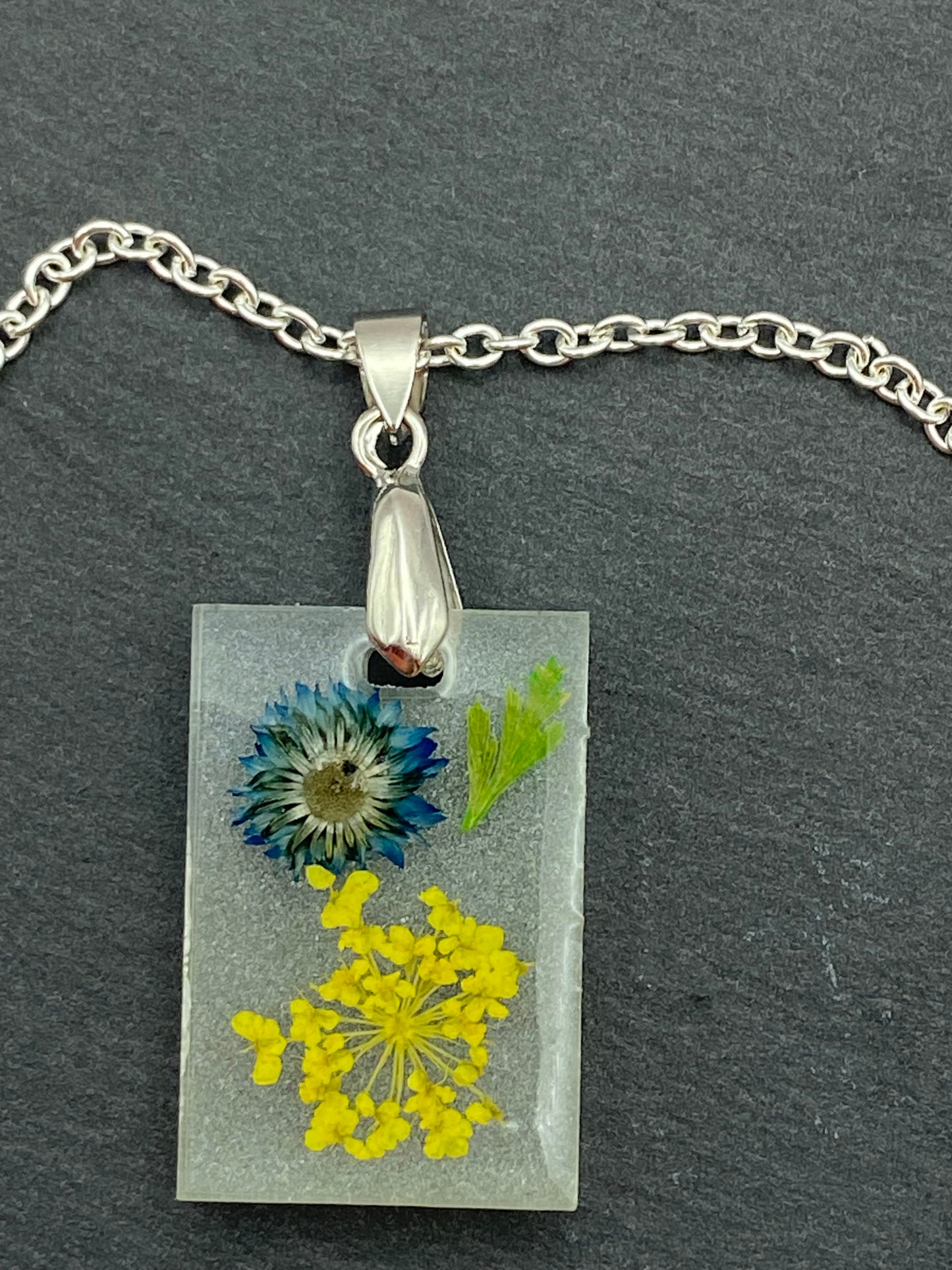 halsketting met rechthoekige hanger met bloemen en met draaisluiting